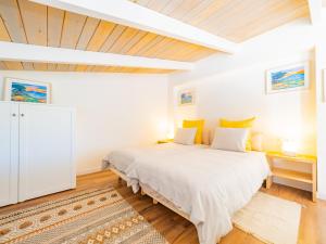 sypialnia z białym łóżkiem i drewnianym sufitem w obiekcie Cubo's Villa Loft El Parador de la Sierra w mieście Alhaurín el Grande