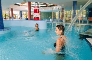 twee kinderen spelen in een zwembad bij Thermal Hotel Balance Lenti in Lenti