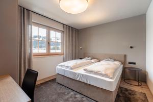 a bedroom with a bed and a window and a table at Chalet 149 Westendorf by ALPS RESORTS in Westendorf