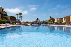 une grande piscine dans un complexe dans l'établissement BUNGALOW BAHÍA MELONERAS, à Meloneras