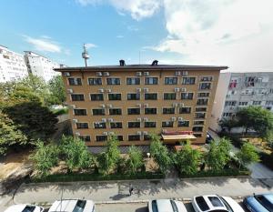 een appartementencomplex met auto's geparkeerd op een parkeerplaats bij Hotel Orient Galati in Galaţi