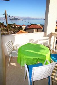 a table and chairs with a green sheet on a balcony at Apartments Nakir in Slatine