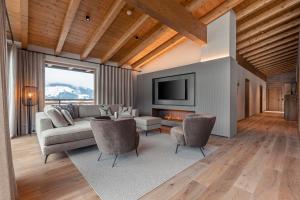 ein Wohnzimmer mit einem Sofa und einem TV in der Unterkunft Chalet 149 Westendorf by ALPS RESORTS in Westendorf