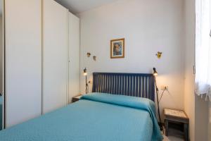 una camera da letto con un letto con una coperta blu di Suite Mare 7 by MMega a Massa