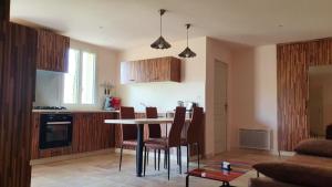 eine Küche mit einem Tisch und Stühlen im Zimmer in der Unterkunft Maison de 2 chambres avec piscine partagee jardin amenage et wifi a Puy l'Eveque in Puy-lʼÉvêque