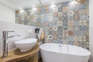 a bathroom with a white tub and a sink at Willa Biały Jeleń Jacuzzi & Sauna in Białka Tatrzańska