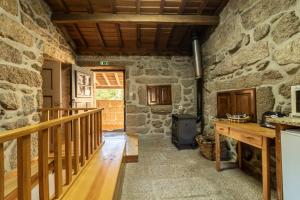 Habitación con pared de piedra y escalera de madera. en Soajo Casa de Campo (PNPG), en Soajo