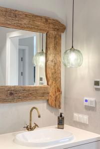 a bathroom sink with two lights and a mirror at Garden Niegocin Apartament in Giżycko