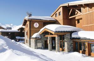 a ski lodge with snow on the roofs at Belambra Clubs Résidence Les Menuires - Le Hameau Des Airelles in Les Menuires