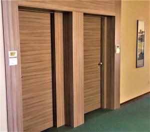 a pair of wooden doors in a room at Hotel Ristorante Alcide in Poggibonsi