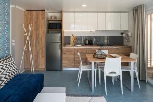 扎达尔Falkensteiner Premium Mobile Homes and Camping Zadar的配有桌椅的厨房和餐厅