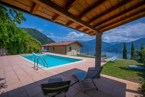 eine Terrasse mit Stühlen und einem Pool in der Unterkunft Villa Aurelia in Plesio