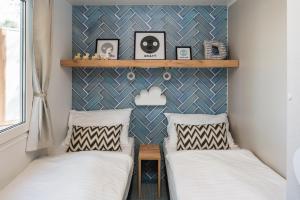 two beds in a small room with a wall at Falkensteiner Premium Mobile Homes and Camping Zadar in Zadar