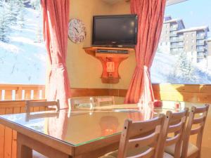 a dining room table with a television in front of a window at Appartement Méribel, 3 pièces, 6 personnes - FR-1-182-181 in Méribel