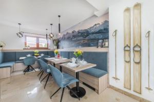 a dining room with a table and blue chairs at Willa Biały Jeleń Jacuzzi & Sauna in Białka Tatrzańska +43 photos