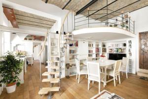 ローマにあるLeopardo 28 - Loft in Trastevereのテーブルと椅子、ロフトが備わる客室です。