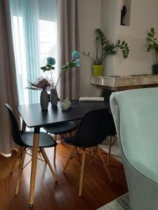 una mesa de comedor con sillas y una mesa con flores. en Brand new brilliant apartment at Athenian Riviera, en Atenas