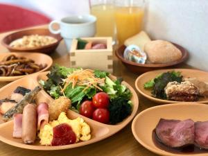einem Holztisch mit Teller mit Lebensmitteln darauf in der Unterkunft APA Hotel Sugamo Ekimae in Tokio