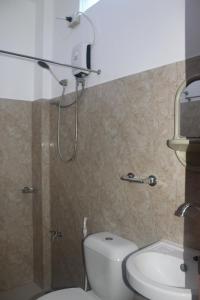 La salle de bains est pourvue d'une douche, de toilettes et d'un lavabo. dans l'établissement Love Vega Hometel, à El Nido
