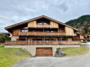 uma grande casa de madeira com uma grande garagem em Le Nid du Corbeau em Morgins