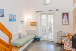 ein Wohnzimmer mit einer Couch und einem Fenster in der Unterkunft The Stone House in Ägina Stadt