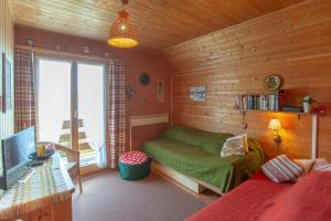 a living room with a couch in a wooden room at Chalet Ruedi - CharmingStay in Flumserberg