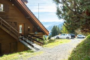 a building with two cars parked outside of it at Chalet Ruedi - CharmingStay in Flumserberg