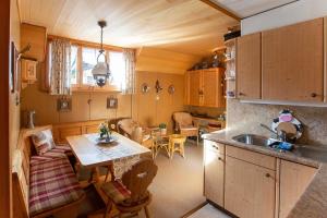 a kitchen and living room with a table and a sink at Chalet Ruedi - CharmingStay in Flumserberg