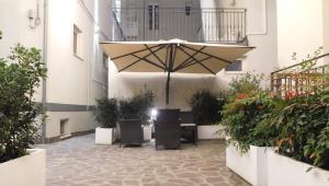 a courtyard with a large umbrella and some plants at Gabbiano Apartments in Rimini