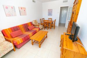 a living room with a couch and a table with a tv at Homeincalpe Apolo XVII 2-22-64 in Calpe