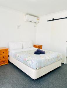 a bedroom with a bed and a dresser at Avenue Motel in Ballarat