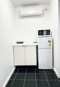a kitchen with a microwave, sink, and refrigerator at Avenue Motel in Ballarat
