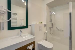 a bathroom with a toilet and a sink and a shower at Hotel Willa Tatrzańska in Krynica Zdrój