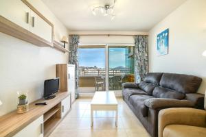 Una sala de estar con un sofá y un televisor. en Homeincalpe Apolo XVII 1-14-41, en Calpe