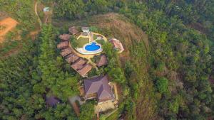 an overhead view of a house with a pool on a hill at Wayanad Village Resort in Koroth