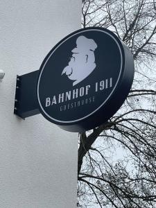 a sign for a building with a mans head on it at Bahnhof 1911 in Wolpertswende