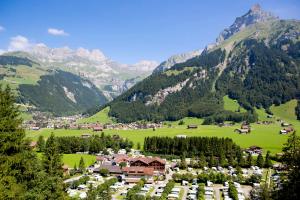 a village in a valley with mountains in the background at Alpenresort Eienwäldli Camping in Engelberg