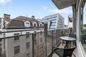 a balcony with a table and chairs on a building at BJØRVIKA APARTMENTS, Teaterplassen, Oslo city center in Oslo
