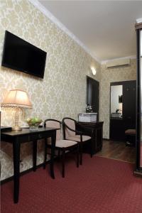 a living room with a table and a television on a wall at Eliseeff Arbat Hotel in Moscow