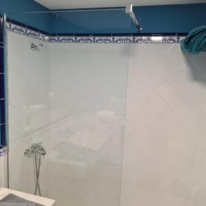 La salle de bains est pourvue d'une douche avec une porte en verre. dans l'établissement Oasis Royal D311, à Corralejo