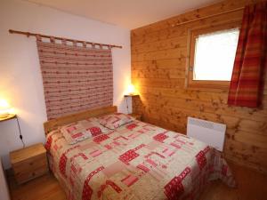 a bedroom with a bed and a wooden wall at Appartement Villard-sur-Doron, 3 pièces, 6 personnes - FR-1-293-254 in Villard-sur-Doron