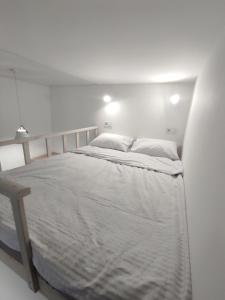 ein weißes Schlafzimmer mit einem Bett in einem Zimmer in der Unterkunft Victory park apartments in Poltawa