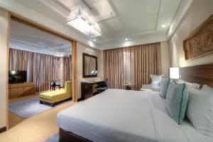 a hotel room with a large bed and a living room at The Raintree, St. Mary’s Road in Chennai