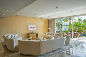 FIVE Palm Beach Villa - Three Floors, Private Pool, Jacuzzi في دبي: غرفة معيشة مع أريكة وكراسي كبيرة