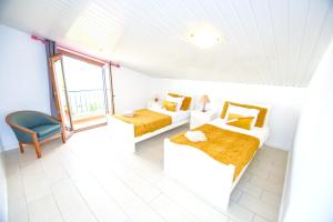 a white room with two beds and a chair at Authentic House in Funchal + City View in Funchal +38 photos