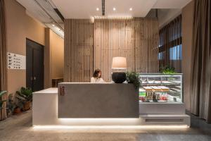 a woman sitting at a counter in a store at SI Hotel in Taichung