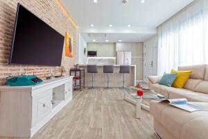 a living room with a large flat screen tv on a brick wall at Genteel Home Castilla Terrace in Seville