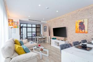 un soggiorno con divano bianco e parete di mattoni di Genteel Home Castilla Terrace a Siviglia
