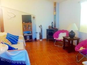 uma sala de estar com um sofá e cadeiras em 2 bedrooms house with terrace at Nazare 1 km away from the beach na Nazaré