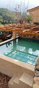 a pool of water with a wooden bridge over it at Can Peñes in Port d’Andratx